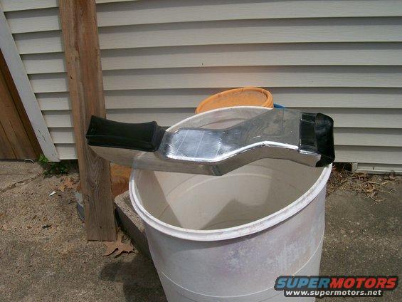 Chrome air intake duct with black end caps resting on a white bucket