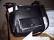1993 Ford Probe - A black leather handbag with white trim and a silver clasp is shown with its tags still attached.