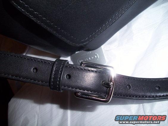 Black leather bag strap with silver buckle and Coach tag