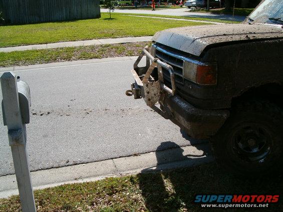 1991 Ford Bronco front end covered in mud, with a brush guard and tow hitch