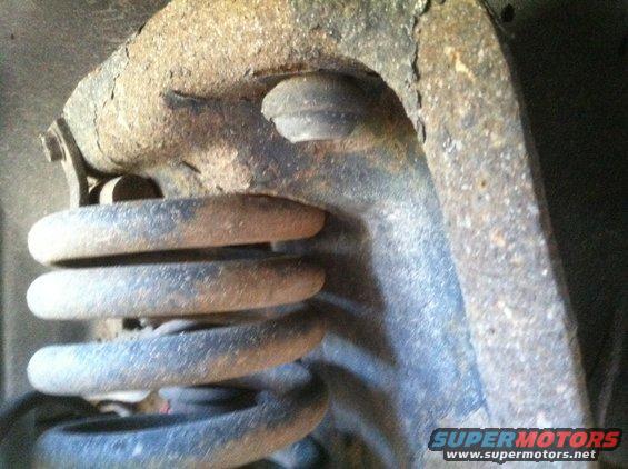 Close-up of a rusted coil spring and suspension component