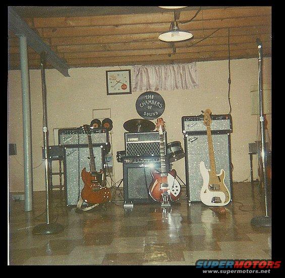 Band practice space with guitars, amplifiers, drums, and microphones