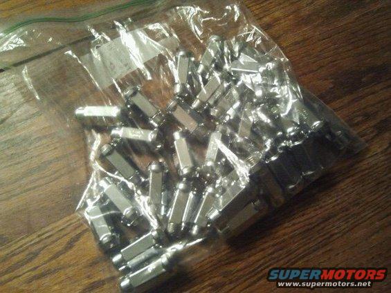 Bag of chrome lug nuts on wooden surface