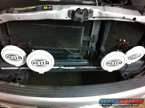 Four Hella fog lights mounted in front of a vehicle's radiator