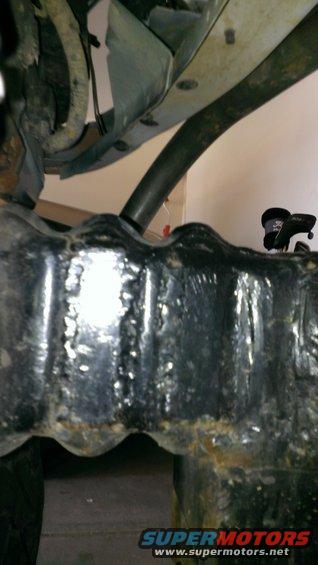 Underside of a vehicle showing frame and suspension components. SuperMotors.net logo visible
