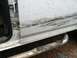 1992 Ford C-350 (Centurion Conversions) - Close-up of a dirty truck door and running board, showing wear and tear.