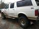 1992 Ford C-350 (Centurion Conversions) - This white 1992 Ford C-350 Centurion Conversions SUV shows significant mud splatter and damage along its side.