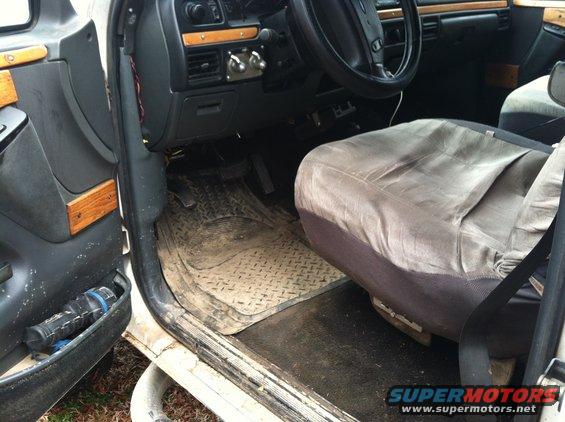 1992 Ford C-350 (Centurion Conversions) interior showing worn gray seat covers, diamond plate floor mats, and wood trim