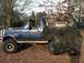 1992 Ford C-350 (Centurion Conversions) - A blue pickup truck with a "Bronco" badge is parked outdoors, its rear covered by a tarp.