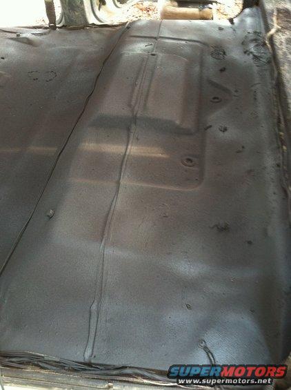 Interior floor of a vehicle, showing metal with some texture and a seam