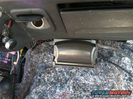 Interior shot of vehicle dashboard with exposed wiring and a small black compartment