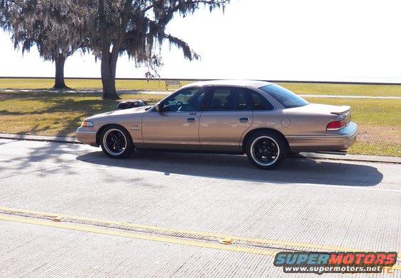 Tan 1993 Ford Crown Victoria sedan, side view, black wheels