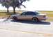 1993 Ford Crown Victoria - A tan 1993 Ford Crown Victoria sedan is parked by the water, aftermarket black wheels.