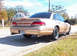 1993 Ford Crown Victoria - Rear view of a gold sedan with aftermarket wheels and a spoiler. The license plate is visible.
