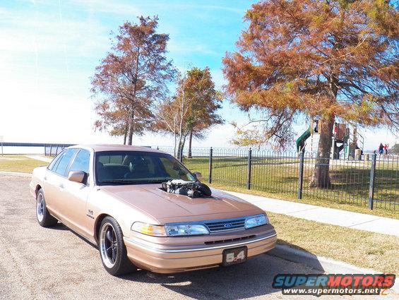 1993 Ford Crown Victoria with engine exposed through hood, parked roadside