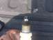 2004 Dodge 1500 - A single spark plug is shown, held by a hand with grease stains.