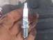 2004 Dodge 1500 - A Champion spark plug, model 12MCC4, is held in a hand with visible dirt and grease.