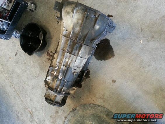 Transmission part on concrete floor with oil pan