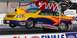 2003 Ford Crown Victoria - A drag racing car is captured mid-air during a race, adorned with numerous sponsor decals.