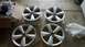 2008 Mercury Grand Marquis - A set of four alloy wheels, likely for a performance car, are shown resting on cardboard in a garage or workshop.