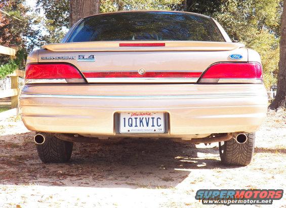 Tan Ford Crown Victoria rear view with dual exhaust pipes and Louisiana license plate