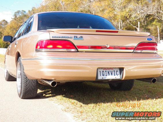 Gold sedan rear view, 'Crown Victoria 5.4' badge visible