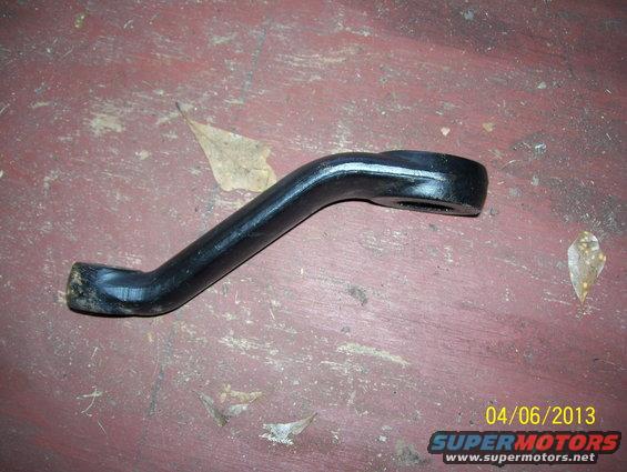 Black metal automotive part on red surface