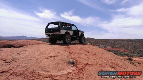 Dark green and silver SUV parked on a rocky outcrop, doors open