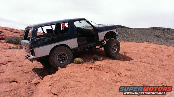 1994 Ford Bronco on red rocks, doors open, lifted suspension