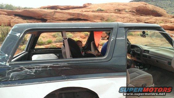 1990s Ford Bronco interior, side view, showing baby in car seat and dashboard