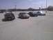 2003 Ford Crown Victoria - A group of sedans, including a maroon 2003 Ford Crown Victoria, are parked in an outdoor lot.