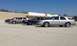 2005 Ford Crown Victoria - Several Ford Crown Victorias are parked in a lot in front of a store.
