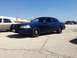 2005 Ford Crown Victoria - A dark blue sedan, possibly a police car, is parked in a lot under a clear sky.