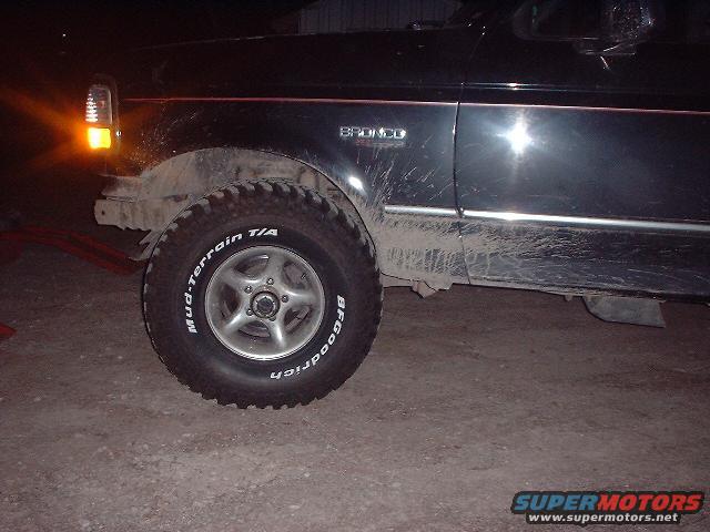 Side view of a black 1993 Ford Bronco with BFGoodrich Mud-Terrain T/A tires. The vehicle is dirty