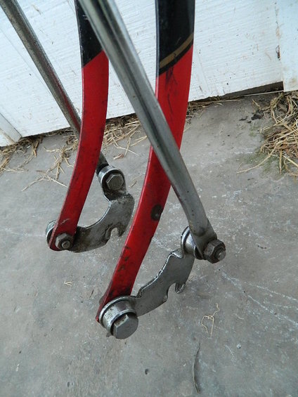 close-up of red and black bicycle frame dropouts with silver metal parts