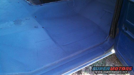 Blue painted interior floor and door sill of a vehicle, showing some rust and repair marks