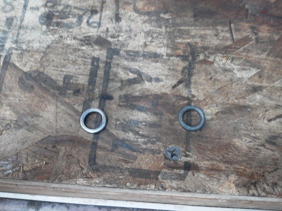 Two metal washers and a screw on a piece of wood