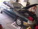 1993 Ford Probe - A dark green sedan, possibly a 1993 Mazda MX-6, is parked in a garage with its hood open, revealing the engine bay.