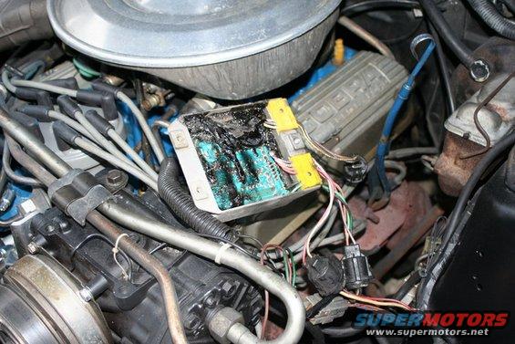 Engine bay shot showing a burnt electronic control module and wiring. A 'COBRA' valve cover is visible