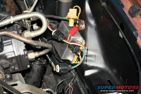 Close-up of vehicle wiring harness and electrical components in engine bay