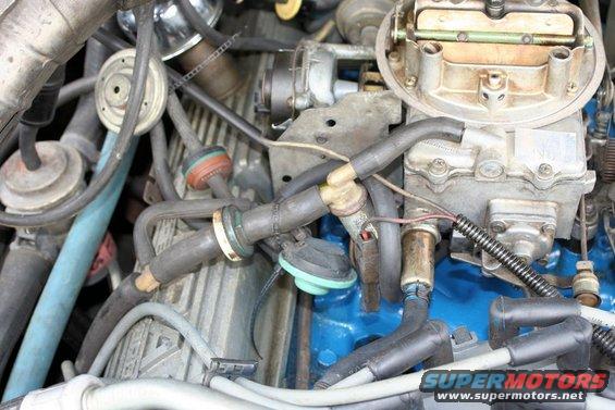 Engine bay with carburetor, distributor, and spark plug wires visible