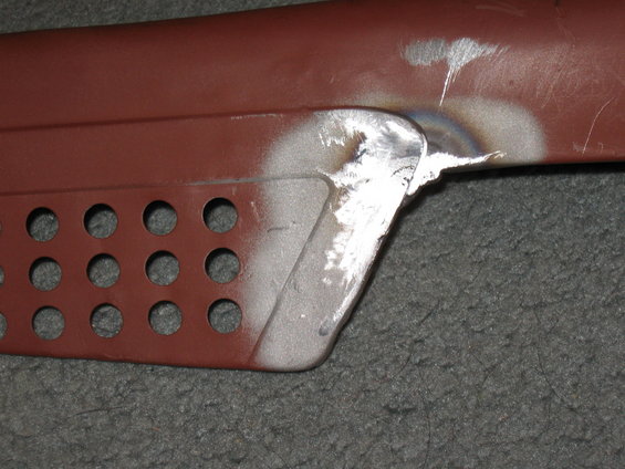 Welded metal part with rows of circular holes, showing grinding marks and weld splatter