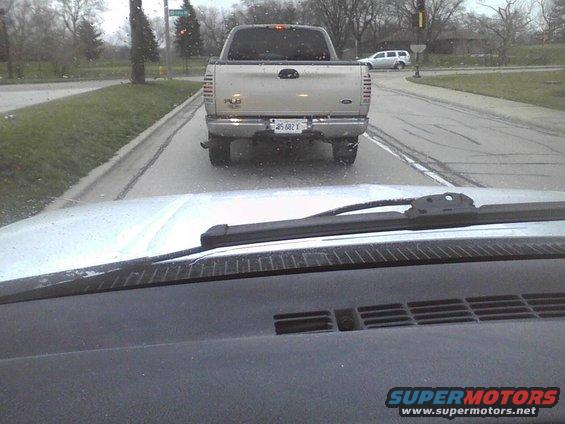 Rear view of silver pickup truck with license plate J5 682 X