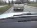 2003 Ford Crown Victoria - A silver pickup truck is seen from behind on a wet road, with another vehicle visible in the distance.