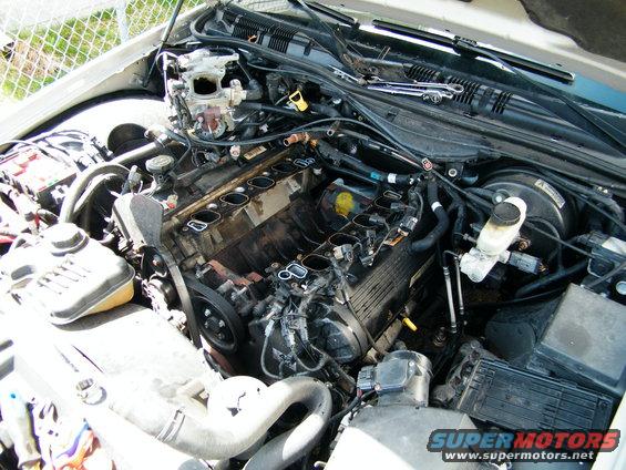 Engine bay with parts removed, showing the V8 engine