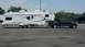 2011 Ford F-250 - A black 2011 Ford F-250 Super Duty tows a large white fifth-wheel camper trailer.