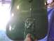 2003 Ford Crown Victoria - A hand is painting a vehicle's fuel tank green in what appears to be a workshop.
