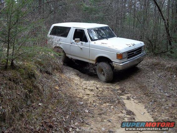 1990 Ford Bronco on a dirt trail in the woods