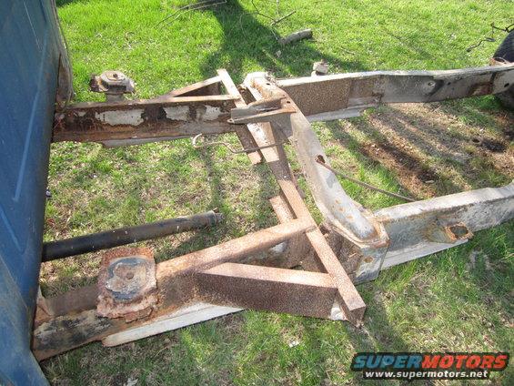 rusted vehicle frame with blue body panel on left