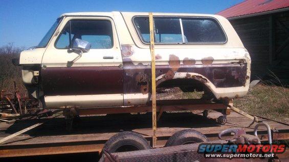 Side view of a 1979 Ford Bronco body, tan and brown, on a trailer